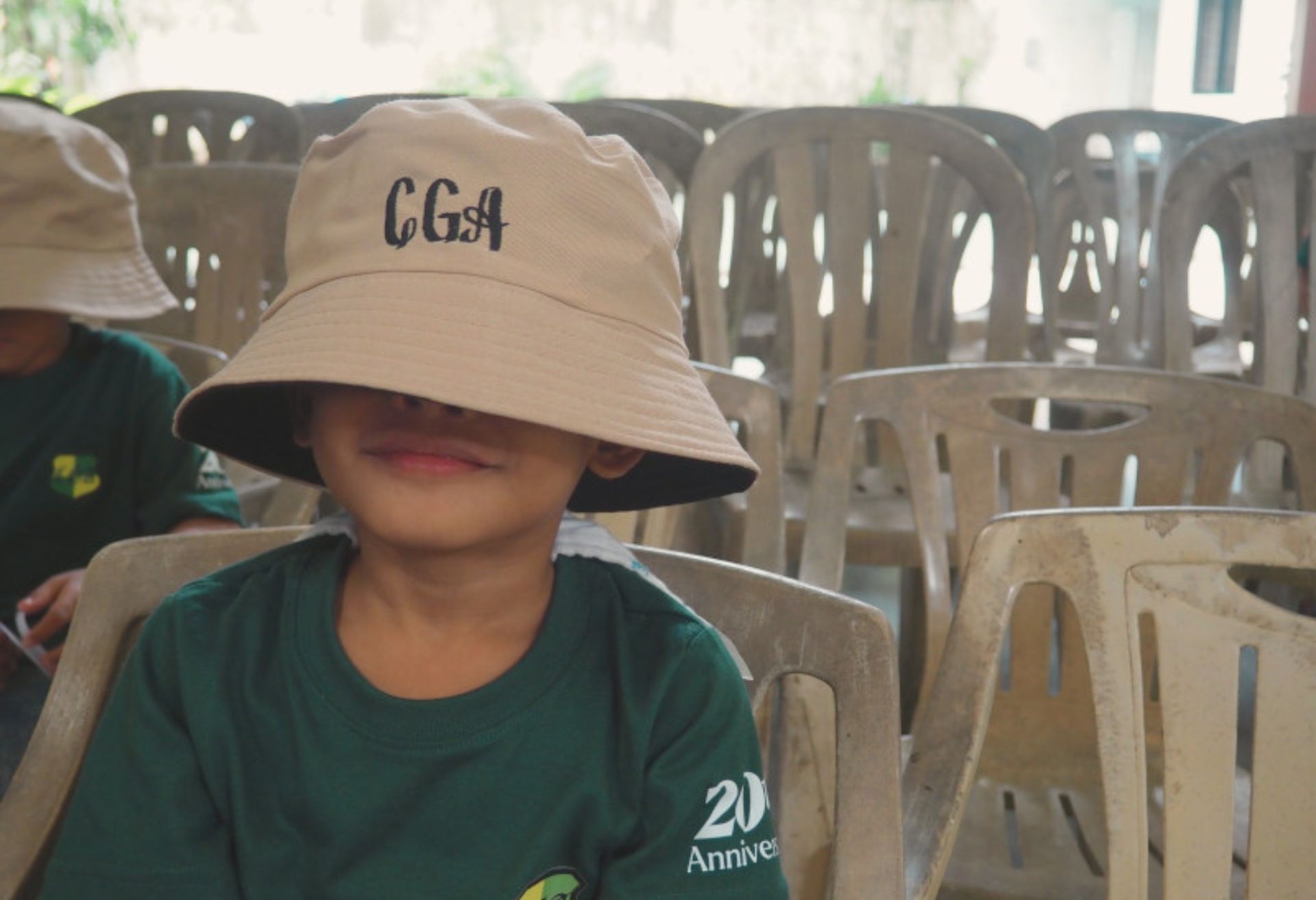 Photograph of a child wearing an oversized hat